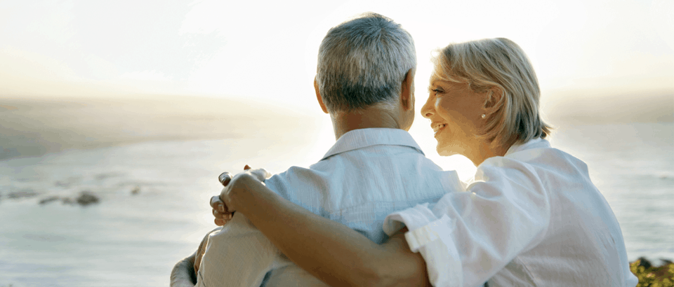 Older couple embracing looking out on the water